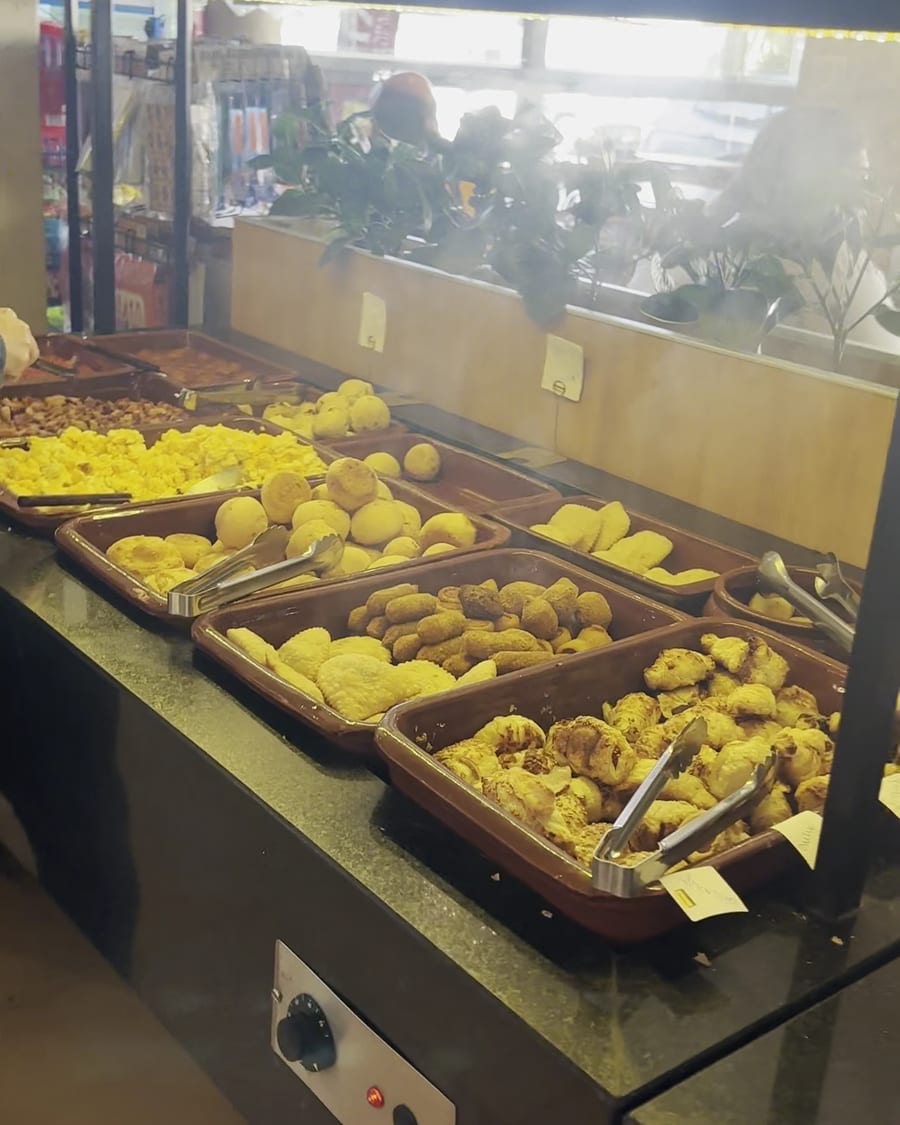 Balcão aquecido com pães de queijo e salgadinhos