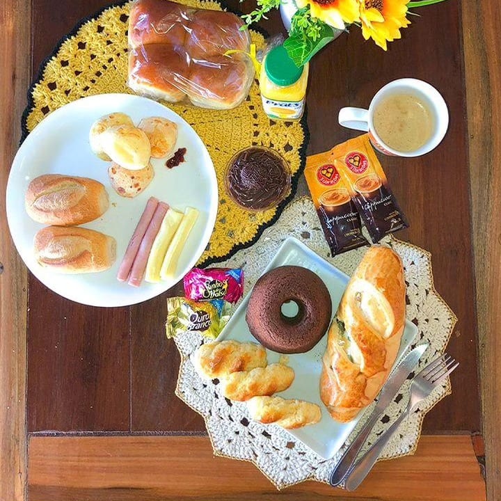 Mesa posta de café da manhã com pães, frios e café