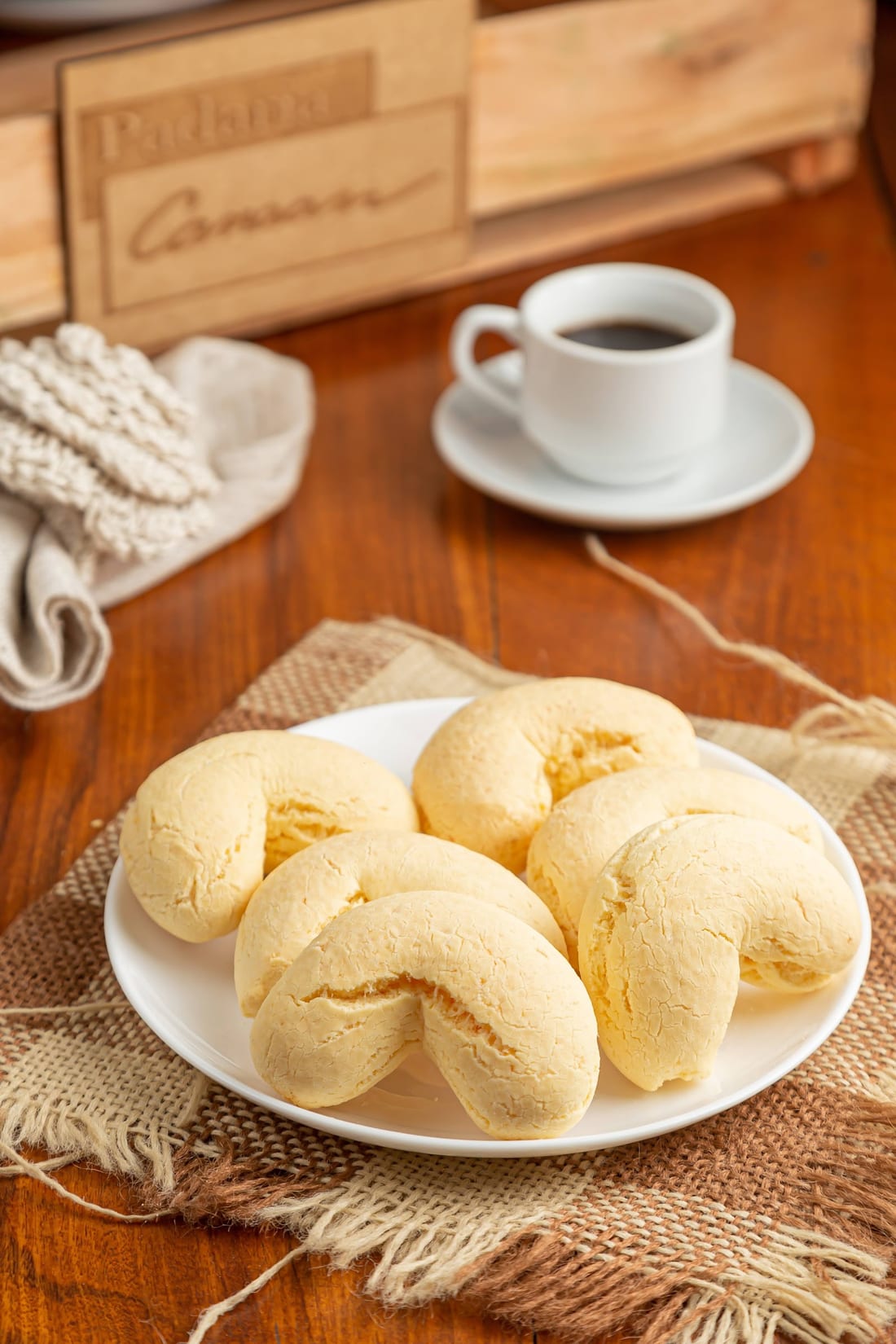 Biscoito de queijo com café quentinho na mesa de madeira