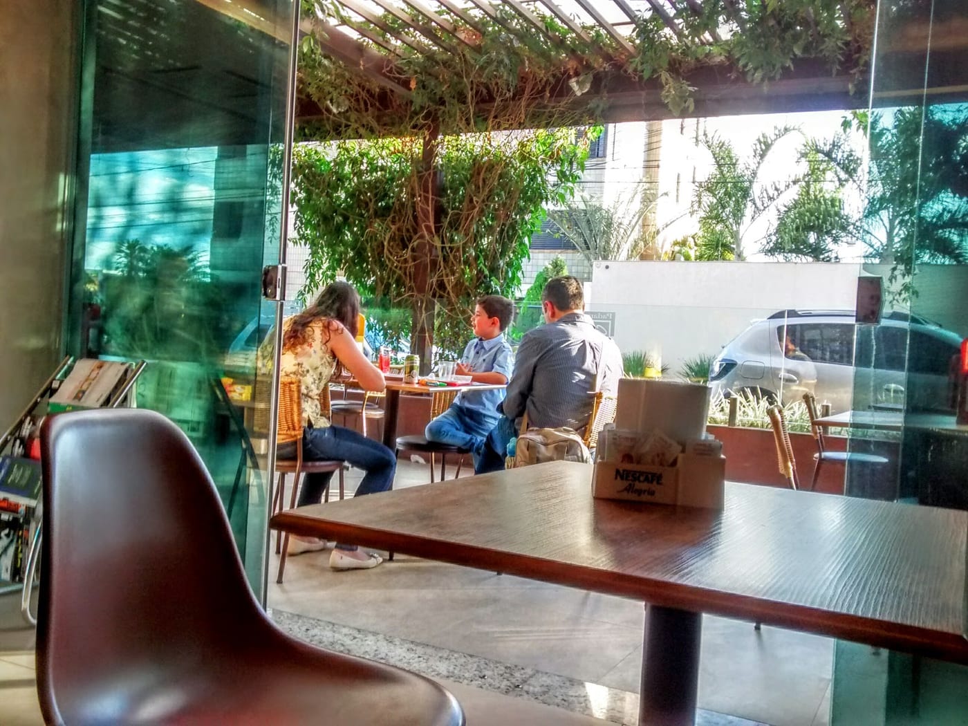 Varanda da Padaria Canaan com mesas e plantas