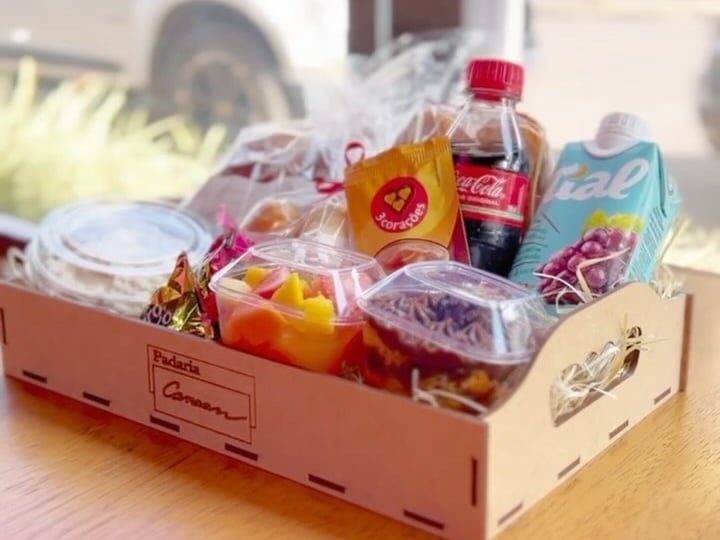 Cesta de café da manhã montada pelo grupo, com bolo de pote, frutas, café e suco